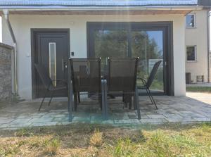 a table and chairs sitting on a patio at Wasserschloss Apt - von Taube Refugium für 1-2 Personen mit Terasse, Küche, Garten, Wifi, TV, Bar, Dusche, Waschmaschine, Parkplatz, versteckt gelegen in Neukirchen