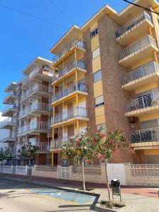 ein großes Apartmenthaus mit einem Baum davor in der Unterkunft The Cozy Coast in Piles + 6 Fotos