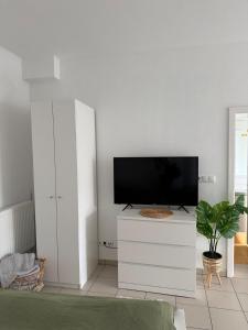 a living room with a flat screen tv on a white dresser at Tropical Room Modern Cozy in Bad Nauheim