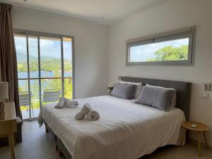 Un dormitorio con una cama grande con toallas. en EAST KEYS - East Blue Villas, en Le Vauclin