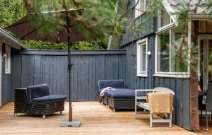 two chairs and an umbrella on a patio at Three-Bedroom Holiday Home In Hovborg in Hovborg +12 photos