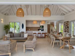 Una sala de estar con mesa y sillas y una cocina. en EAST KEYS - East Blue Villas, en Le Vauclin 32 fotos más