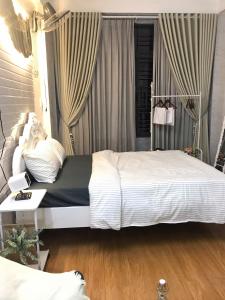 a bedroom with a large white bed and a desk at DU Home Huế 2 in Thôn Trường Giang