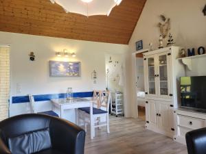 布特亚丁根Ferienhaus Klein的带桌子和电视的餐厅
