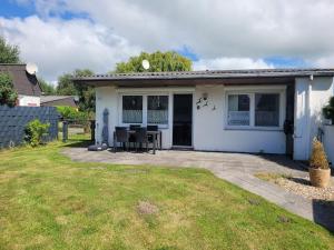 布特亚丁根Ferienhaus Klein的白色的小房子,配有桌子和椅子