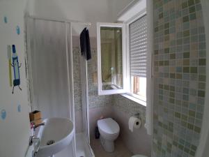 a bathroom with a sink and a toilet and a window at Casa vacanze La Giannina in Grosseto