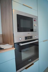 a microwave oven sitting on top of a stove at T2 cosy - Ti nid vert in La Possession +18 photos