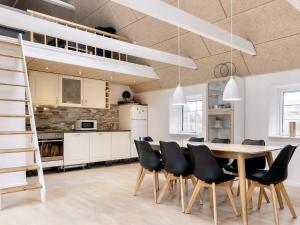a kitchen with a dining room table and chairs at 6 person holiday home in Løkken in Løkken +35 photos