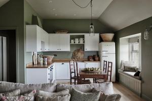 a kitchen with white cabinets and a table with chairs at Banchory Farm in Fife