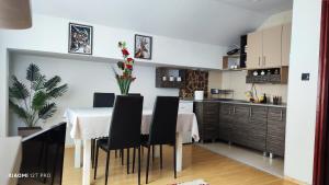a kitchen with a table and black chairs in a room at JetNest in Niš