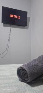 ein Schild mit der Aufschrift „Netflix“ auf einem Bett in der Unterkunft Studio 42 próximo a UFT e Praias in Palmas