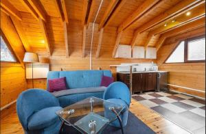 a living room with a blue couch and a table at Domki Port Jastarnia in Jastarnia