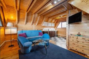 a living room with a blue couch and a television at Domki Port Jastarnia in Jastarnia