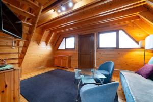a living room with a couch and chairs in a cabin at Domki Port Jastarnia in Jastarnia +2 photos