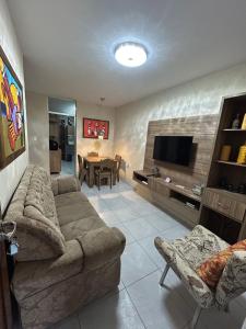 ein Wohnzimmer mit Sofa und Fernseher in der Unterkunft Temporada CG - Casa altíssimo padrão no Cruzeiro in Campina Grande