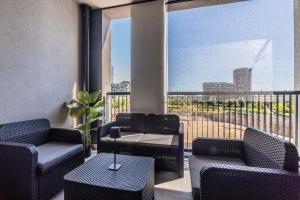 a room with chairs and tables and a balcony at Prime Living Milano Merlata - Balcony Apartment in Milan