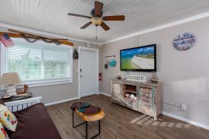 un salon avec un canapé et une télévision à écran plat dans l'établissement Tropic Terrace #32 - Beachfront Rental, à St. Pete Beach