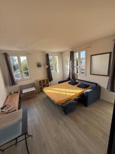 a bedroom with a large bed and a couch at Studio au cœur du village d'arts in Dives-sur-Mer