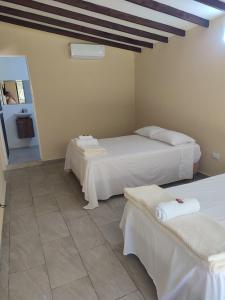 a room with two beds and two chairs in it at Finca el porvenir cabañas viviendas turísticas in Cisneros