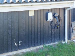 a fence with a security camera on the side of a house at 10 person holiday home in Juelsminde-By Traum in Sønderby