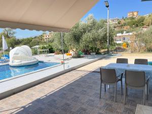 a patio with a table and chairs and a pool at Anastasias apartments in Sarandë