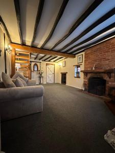 a living room with a couch and a fireplace at Rosemary cottage in Mountnessing