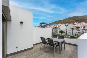 un patio con tavolo e sedie su un balcone di Karat Villa Portofino a Los Cristianos