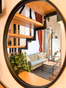 a mirror reflecting a living room with a couch at T25 Urban Green Hideaway in Budapest