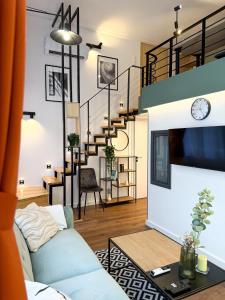a living room with a blue couch and stairs at T25 Urban Green Hideaway in Budapest