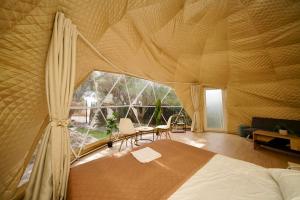 a bedroom with a bed and a large window at Olive Domes in Nea Moudania