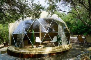 a dome house with a table and chairs in it at Olive Domes in Nea Moudania +11 photos