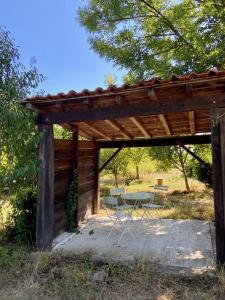 a wooden pergola with a table and chairs at La Colline aux Licornes in Montbron +39 photos
