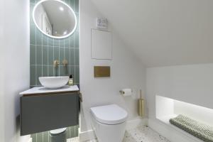 a bathroom with a toilet and a sink and a tub at Luxury One Bed Annnex on Rodborough Common in Woodchester