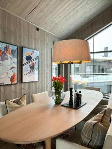 a dining room with a wooden table and a lamp at Modern Family Cabin In Norefjell Ski-Inout in Surteberg