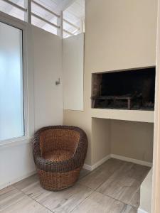 a living room with a wicker chair and a fireplace at Roma apartamento 2 frente al mar in Mar del Plata
