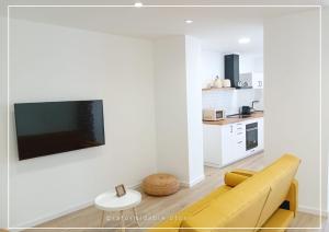 a living room with a couch and a tv on a wall at Casa La formidable in Otos