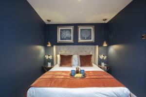 チェルトナムにあるLuxurious 1 Bed Detached Home with Gated Parkingの青い壁の大きなベッドのある寝室 +34枚の写真
