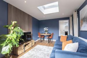 チェルトナムにあるLuxurious 1 Bed Detached Home with Gated Parkingの青い壁のリビングルーム(青いソファ付)