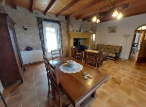 ein Wohnzimmer mit einem Holztisch und Stühlen in der Unterkunft Maison des Hortensias à 500 m des bords de rivière in Limeuil