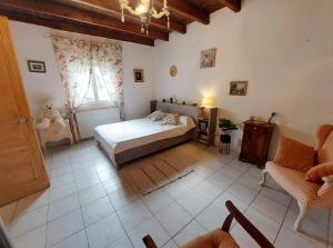 ein Schlafzimmer mit einem Bett und einer Couch und einem Fenster in der Unterkunft Maison des Hortensias à 500 m des bords de rivière in Limeuil