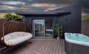 a wicker chair sitting on a deck next to a tub at Bellinter House Hotel & Spa in Navan