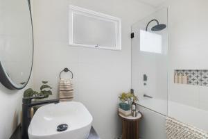 un bagno con un water bianco e un lavandino di Bluewood Cottage - Cozy Charm, Steps from the City a Toowoomba Altre 11 foto