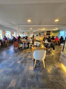 a group of people sitting at tables in a restaurant at Hotel Bahía in Puerto San Julian +27 photos