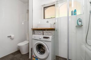un bagno con lavatrice e WC di Compact and Convenient Unit - Hosted by Canstay a Canberra