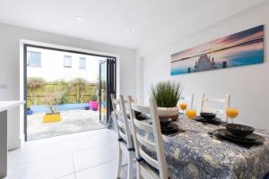 a dining room with a table and chairs and a window at Modern & Spacious Home in Central Cheltenham in Gloucestershire