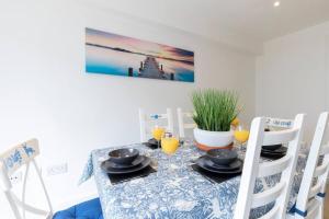 a dining room table with a blue and white table cloth at Modern & Spacious Home in Central Cheltenham in Gloucestershire +25 photos