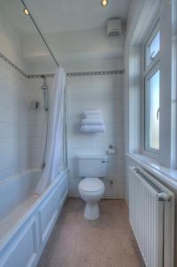 a bathroom with a toilet and a tub and a sink at Royal Inn in Scunthorpe
