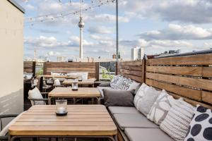 a patio with tables and couches on a roof at Hotel AMANO Rooms & Apartments in Berlin +104 photos