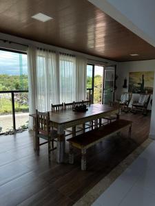 ein Esszimmer mit einem Holztisch und Bänken in der Unterkunft Casa para alugar em Bananeiras in Bananeiras