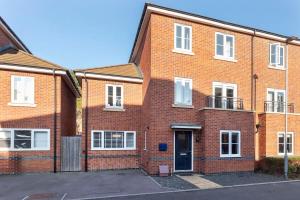 a brick apartment building with a door in front at Stunning 4 Bed 3 Bathroom Home in Gloucestershire